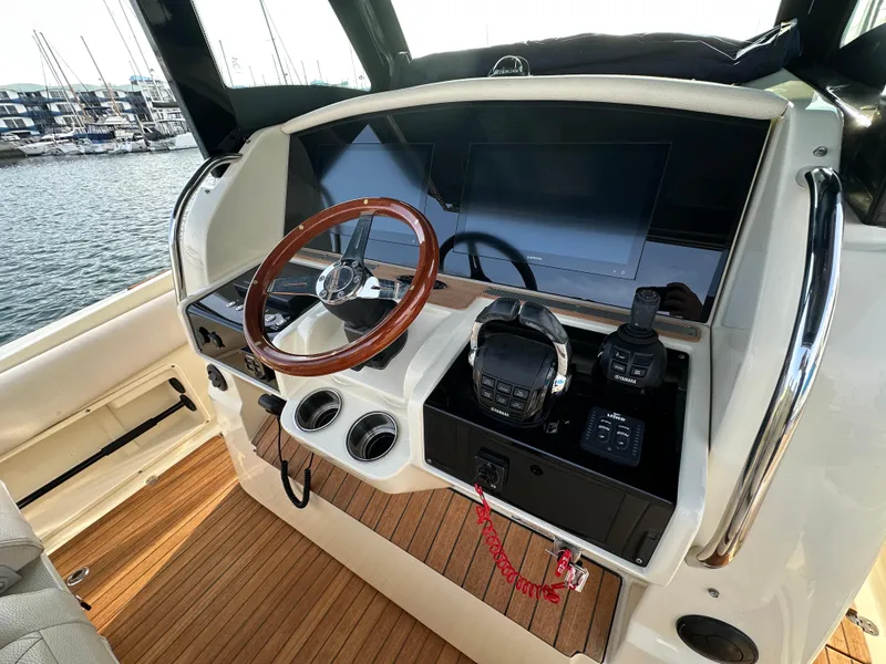 Slide: The Image of The image shows the cockpit of a 2021 Chris-Craft Catalina 34 with a sleek wooden steering wheel. - 12