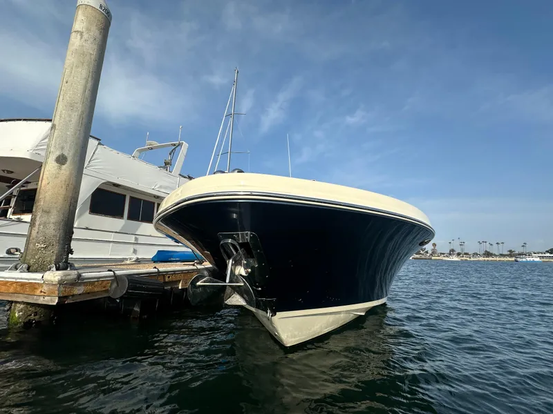 Slide: The Image of A 2021 Chris-Craft Catalina 34 docked in the water, featuring a blue hull and beige deck. - 2