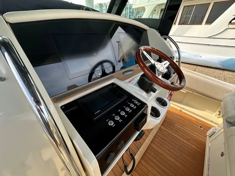 Slide: The Image of The cockpit of the 2021 Chris-Craft Catalina 34 features a sleek dashboard with a wooden steering wheel. - 14