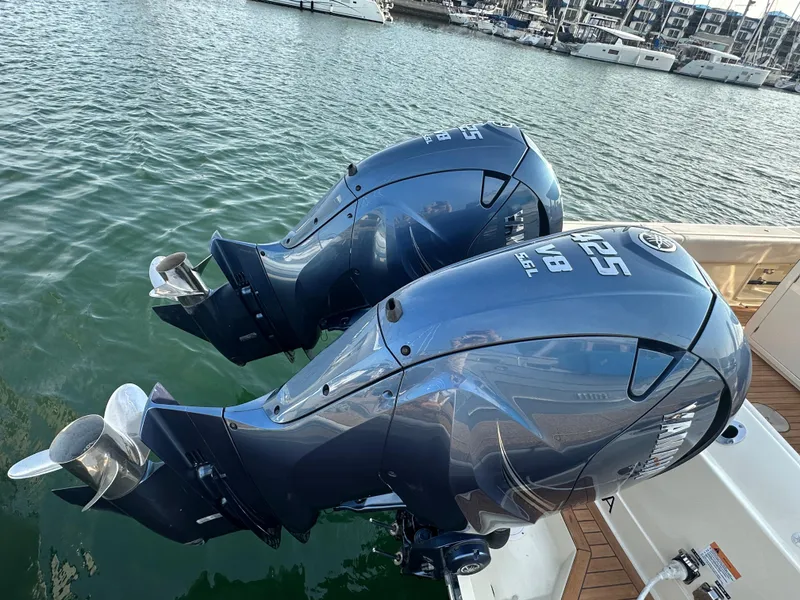 Slide: The Image of Two powerful outboard engines on a Chris-Craft Catalina 34 boat, resting in the water. - 34