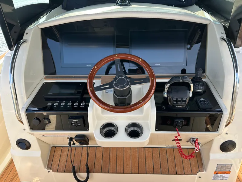 Slide: The Image of The image shows the helm of a 2021 Chris-Craft Catalina 34 with a wooden steering wheel. - 13