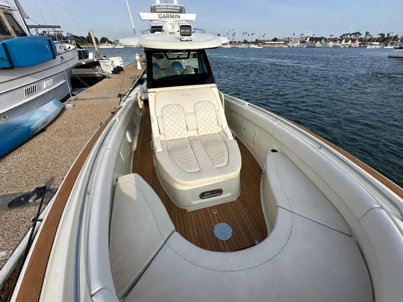 Slide: The Image of The image shows a 2021 Chris-Craft Catalina 34 docked. The foredeck area features comfortable seating. - 21