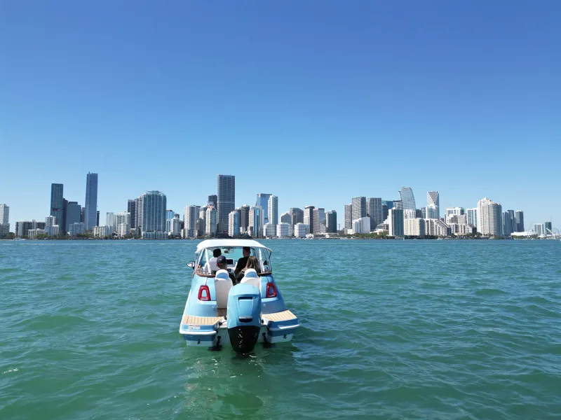 Slide: The Image of Car Off-shore Fiat 500 Classic boat on water with city skyline, 2025 model. - 17
