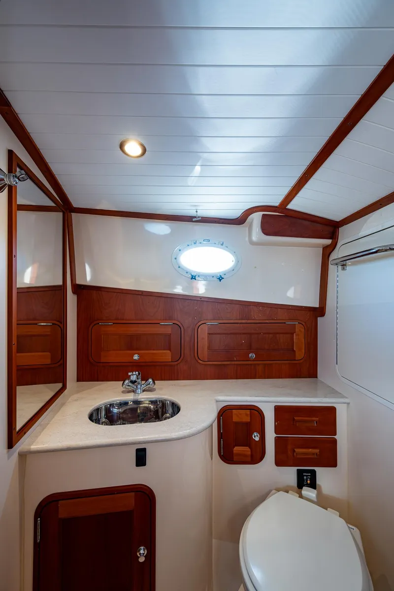 Slide: The Image of 2016 Hinckley Talaria 34 yacht bathroom with wood accents and modern fixtures. - 23