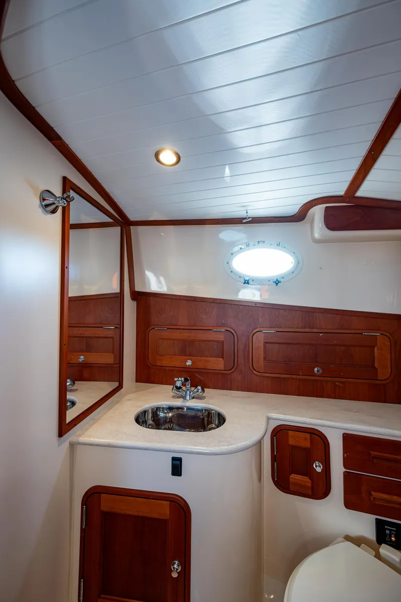 Slide: The Image of 2016 Hinckley Talaria 34 yacht bathroom with wood accents and modern fixtures. - 25