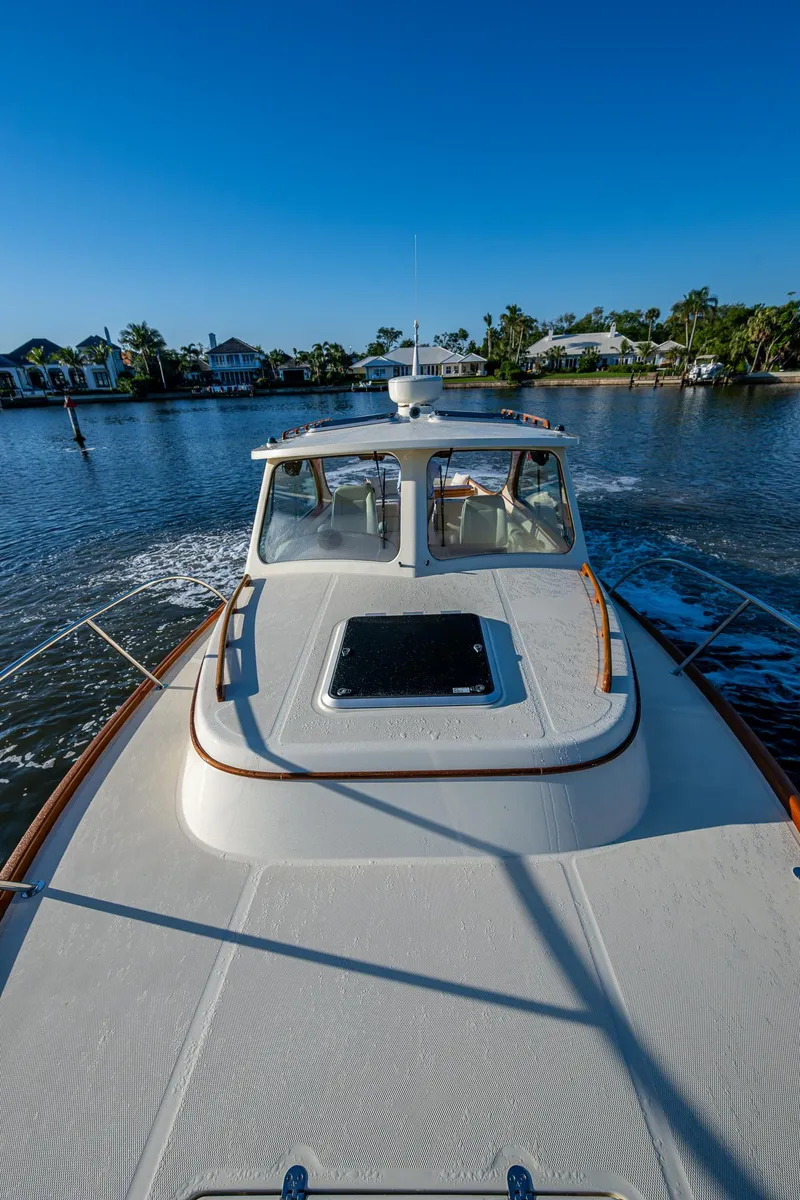 Slide: The Image of 2016 Hinckley Talaria 34 cruising on a calm waterway under a clear blue sky. - 30