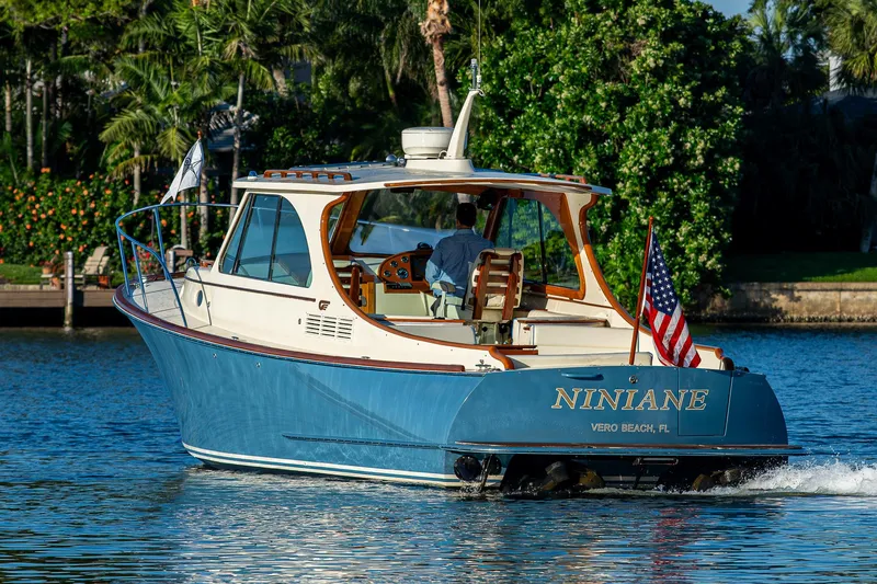 Slide: The Image of 2016 Hinckley Talaria 34 boat cruising on a sunny day, displaying an American flag. - 33