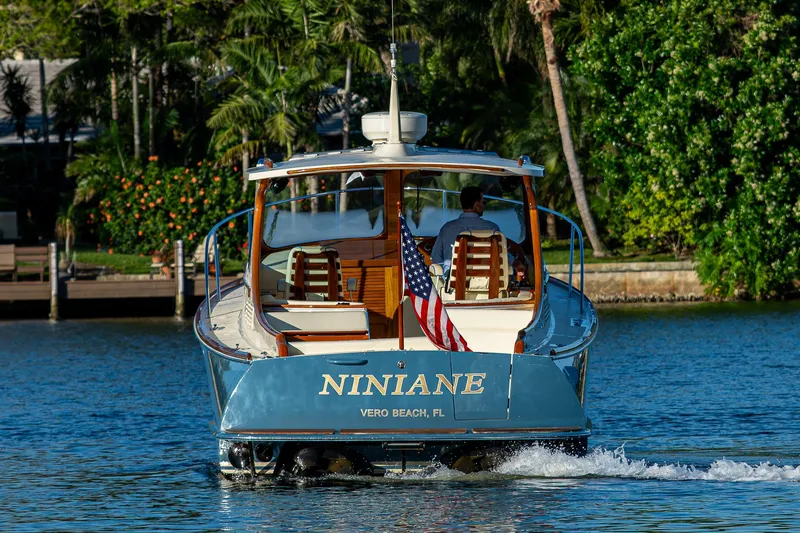 Slide: The Image of 2016 Hinckley Talaria 34 cruising on a scenic waterway with lush greenery. - 4