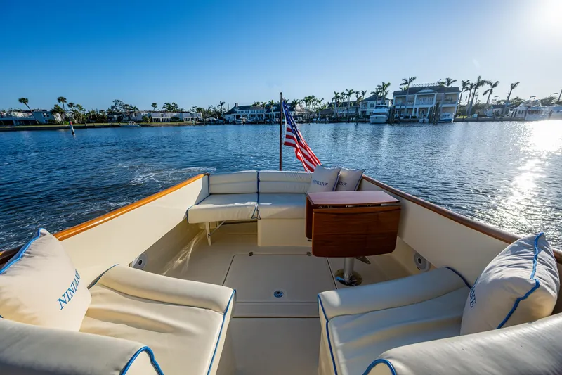Slide: The Image of 2016 Hinckley Talaria 34 boat with elegant seating, cruising on a sunny waterfront. - 7