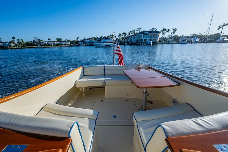 Slide: The Image of 2016 Hinckley Talaria 34 boat with elegant seating and table on calm water. - 8