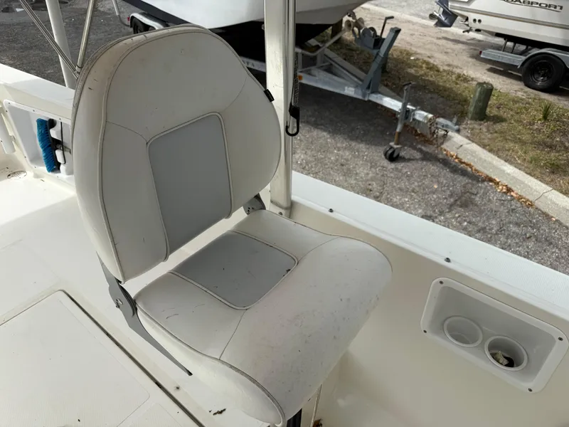 Slide: The Image of Captain's chair on 2015 Atlas Boat Works Pompano 23, with cup holders nearby. - 20