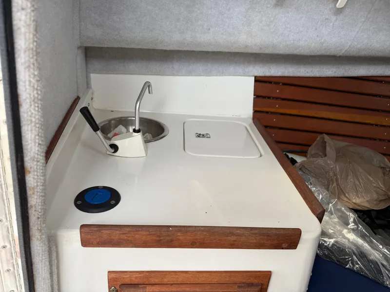 Slide: The Image of Interior of 2015 Atlas Boat Works Pompano 23, featuring a compact kitchenette area. - 31