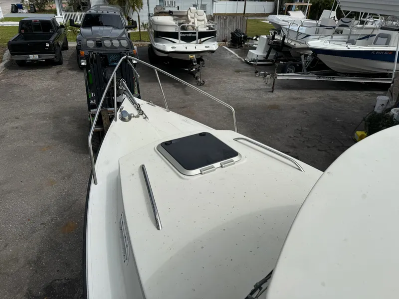 Slide: The Image of 2015 Atlas Boat Works Pompano 23 on trailer, parked among other boats. - 32