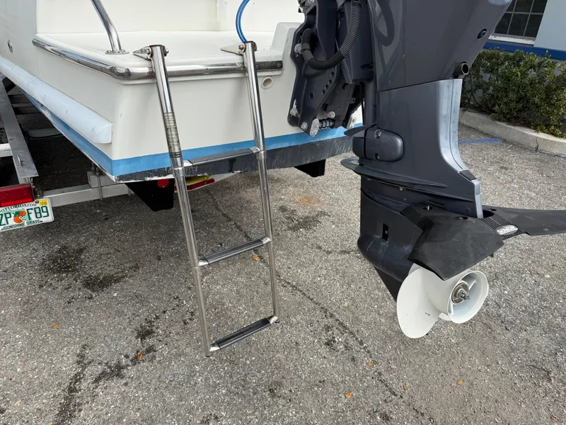 Slide: The Image of Atlas Boat Works Pompano 23, 2015 model, with ladder and outboard motor. - 7