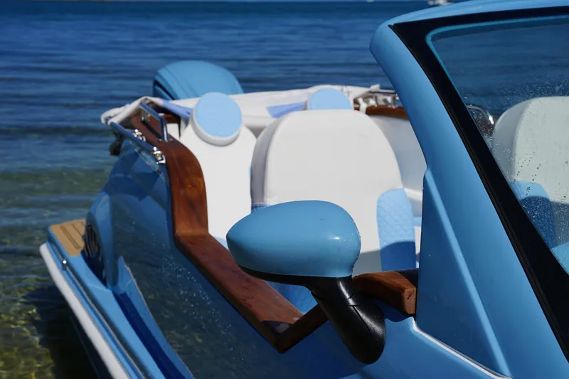 Slide: The Image of Blue Car Off-shore Fiat 500 Classic 2025 on water, featuring sleek design and wooden accents. - 7