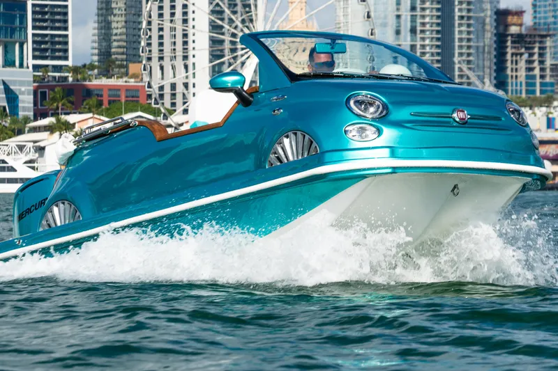 Slide: The Image of 2025 Car Off-shore Fiat 500 Classic boat cruising on water, city skyline background. - 4