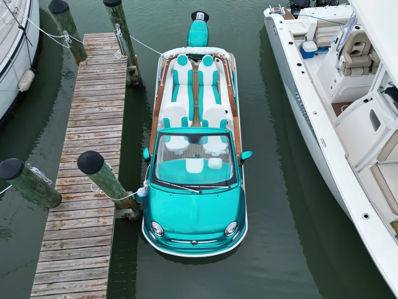 Slide: The Image of Turquoise 2025 Car Off-shore Fiat 500 Classic boat docked between yachts. - 8