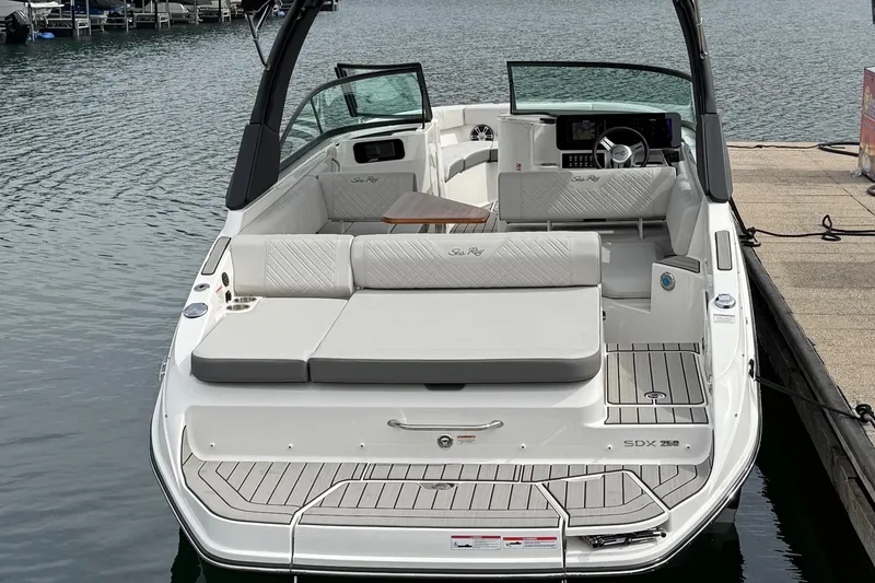 Slide: The Image of 2025 Sea Ray SDX 250 boat with spacious seating, docked on calm water. - 3
