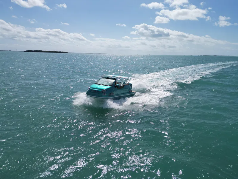 Slide: The Image of 2025 Car Off-shore Fiat 500 Classic driving on water under a sunny sky. - 14