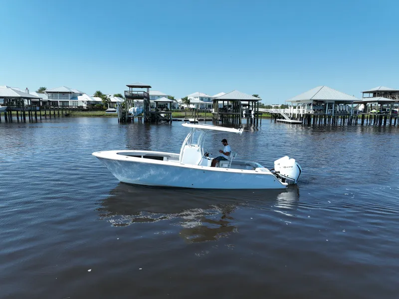 Slide: The Image of 2023 Front Runner 26 Center Console boat on calm water near docks. - 14