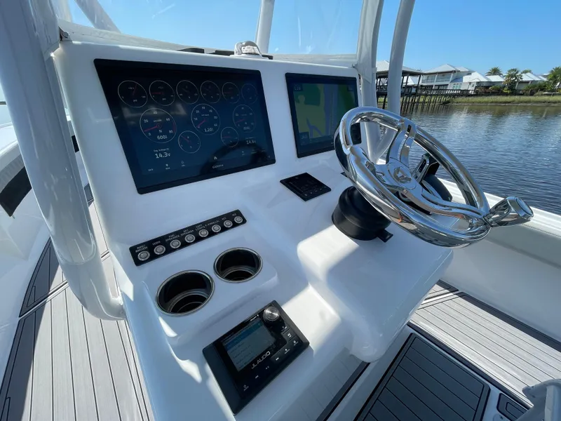 Slide: The Image of 2023 Front Runner 26 Center Console boat dashboard with modern controls and steering wheel. - 21