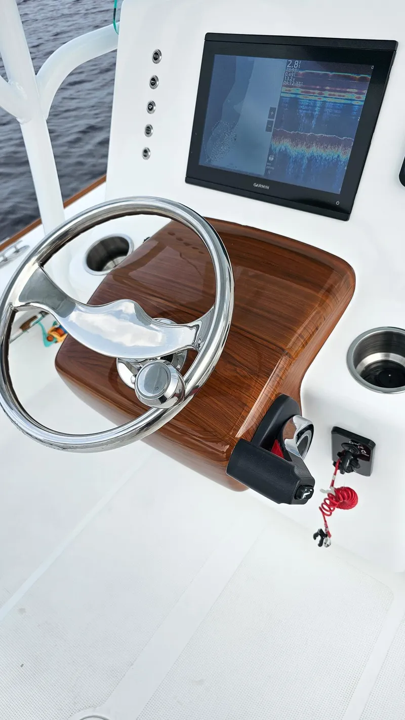 Slide: The Image of 2025 Chaos 21 Tarpon Bay boat dashboard with steering wheel and navigation display. - 11