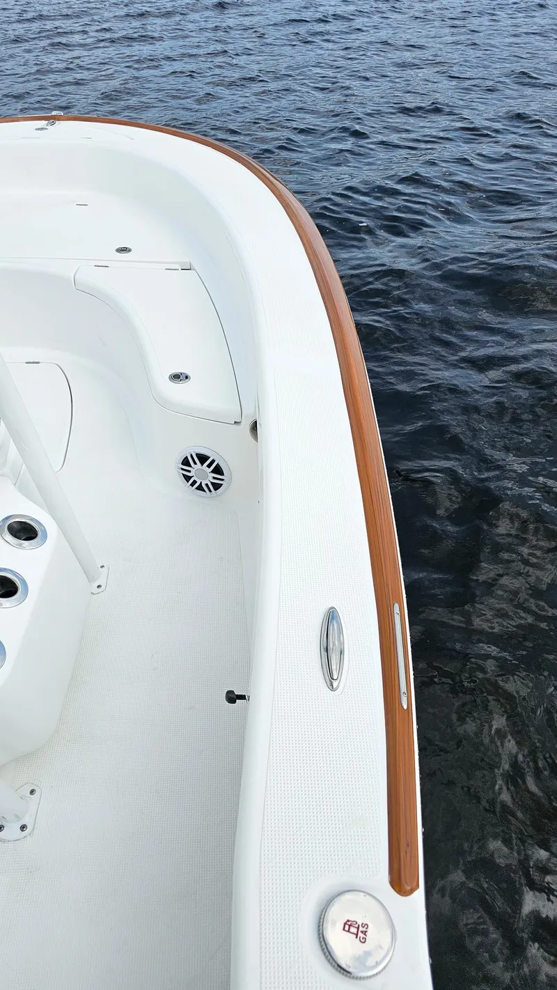 Slide: The Image of 2025 Chaos 21 Tarpon Bay boat, white deck, wooden trim, on calm water. - 13