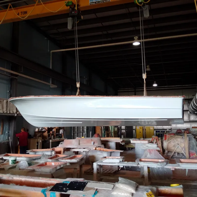 Slide: The Image of 2025 Chaos 21 Tarpon Bay boat hull suspended in a workshop. - 17