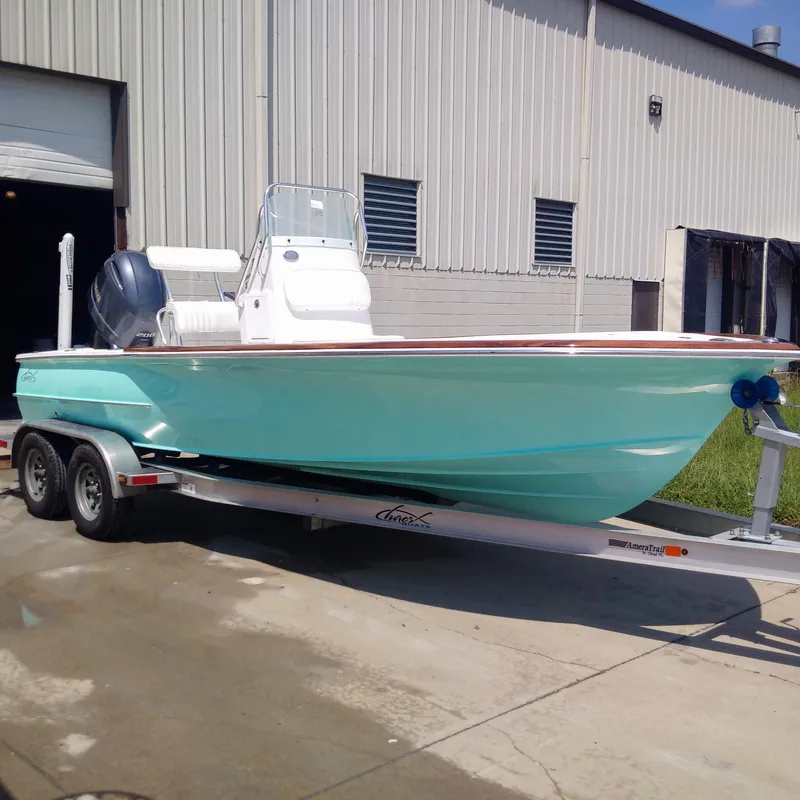 Slide: The Image of 2025 Chaos 21 Tarpon Bay boat on trailer outside industrial building. - 18