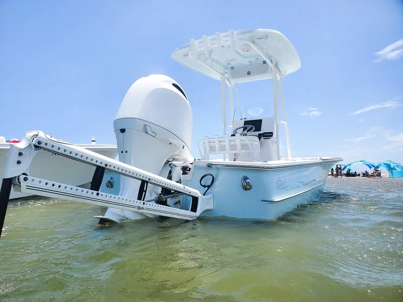 Slide: The Image of 2025 Chaos 21 Tarpon Bay boat in shallow water, clear sky background. - 2
