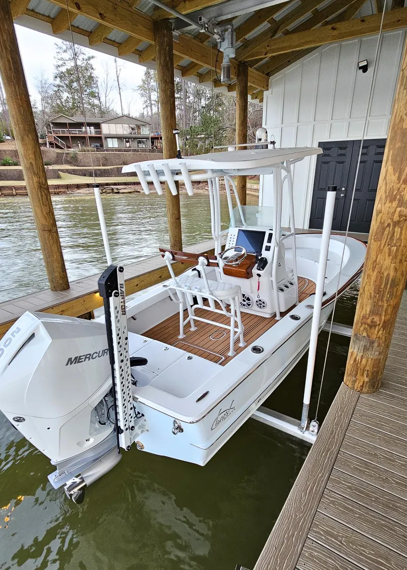 Slide: The Image of 2025 Chaos 21 Tarpon Bay boat docked with Mercury engine, under a wooden shelter. - 4