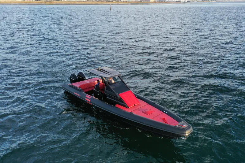 Slide: The Image of 2023 Novielli Veloche 349 boat on open water, featuring sleek black and red design. - 18