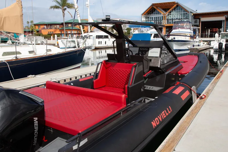 Slide: The Image of 2023 Novielli Veloche 349 boat docked at marina, featuring sleek black and red design. - 4