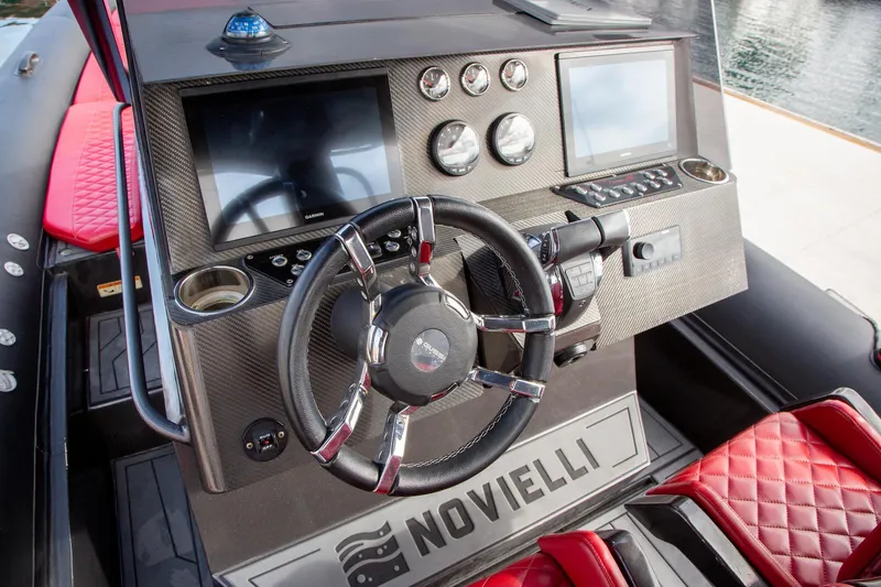 Slide: The Image of 2023 Novielli Veloche 349 boat dashboard with steering wheel, digital displays, and red quilted seats. - 9