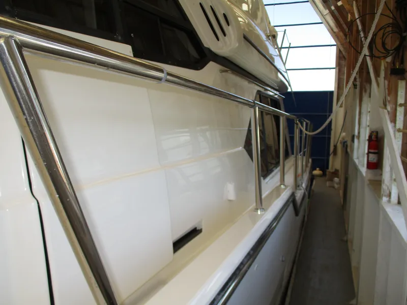 Slide: The Image of 2000 Bayliner 5288 Pilot House yacht docked in a covered marina. - 11