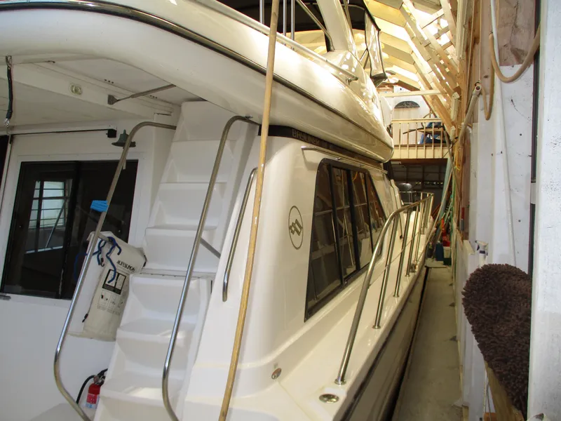 Slide: The Image of 2000 Bayliner 5288 Pilot House yacht in storage, side view with visible stairs and railing. - 23