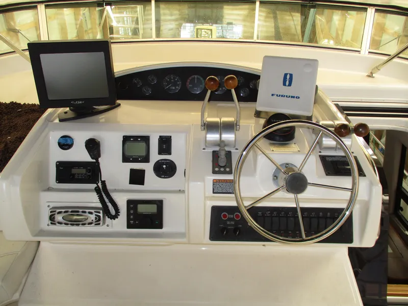 Slide: The Image of 2000 Bayliner 5288 Pilot House helm with steering wheel, controls, and navigation equipment. - 24
