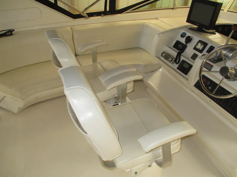 Slide: The Image of 2000 Bayliner 5288 Pilot House interior with white seating and navigation controls. - 26