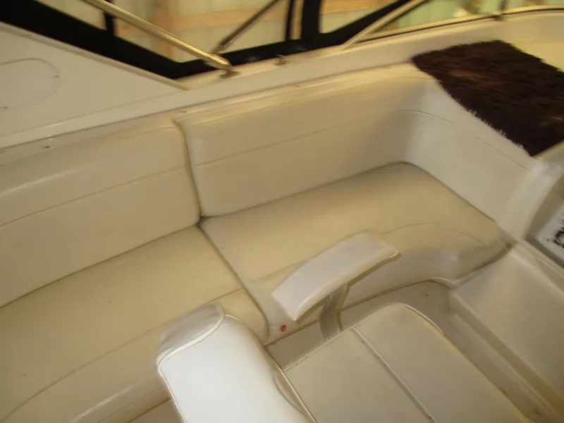 Slide: The Image of 2000 Bayliner 5288 Pilot House interior seating with cream upholstery and armrest. - 27