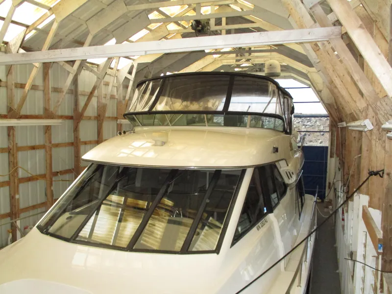 Slide: The Image of 2000 Bayliner 5288 Pilot House yacht stored in a wooden boathouse. - 3