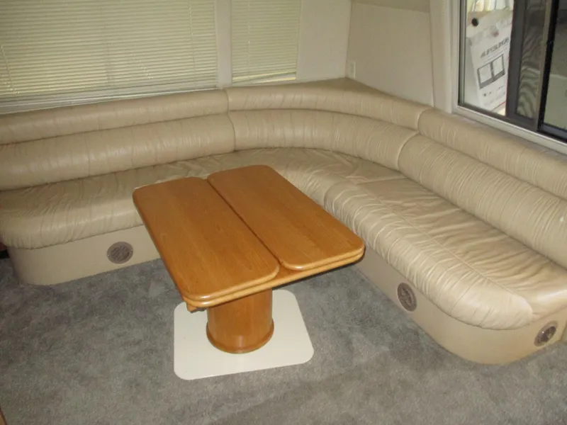 Slide: The Image of Luxurious interior of 2000 Bayliner 5288 Pilot House with beige seating and wooden table. - 38