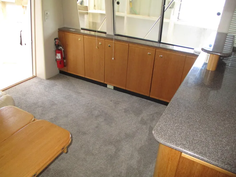 Slide: The Image of Interior of 2000 Bayliner 5288 Pilot House with carpet, wooden cabinets, and countertop. - 40