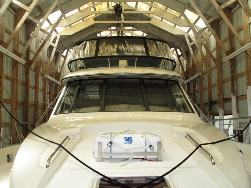 Slide: The Image of 2000 Bayliner 5288 Pilot House yacht stored in a wooden boathouse. - 6