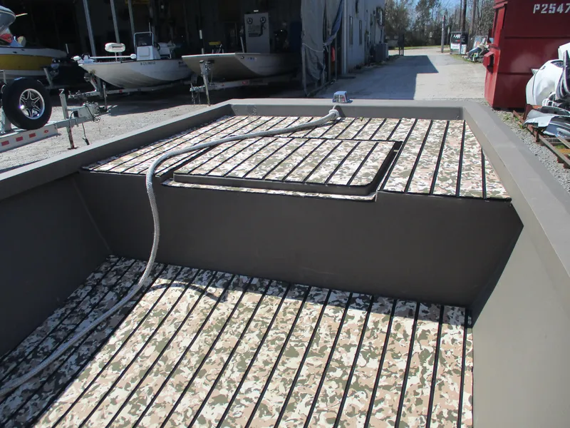 Slide: The Image of Custom 15 Aluminum boat interior with camouflage flooring, 2023 model, docked outdoors. - 2