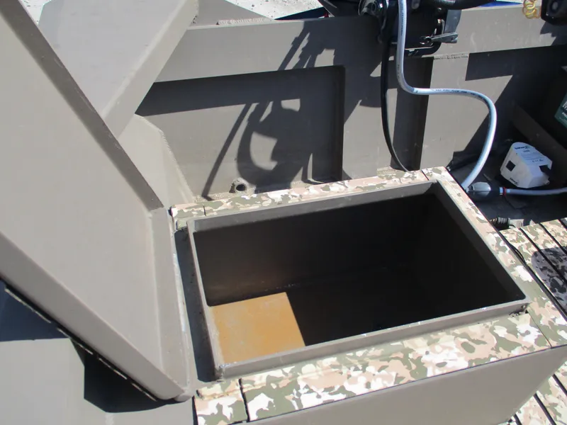 Slide: The Image of Open storage compartment on a 2023 Custom 15 Aluminum boat with camouflage trim. - 6