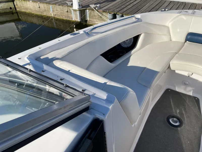 Slide: The Image of 2008 Regal 2700 Bowrider boat interior with white seating and dockside view. - 10