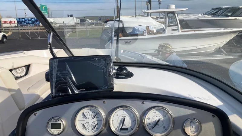 Slide: The Image of 2008 Regal 2700 Bowrider dashboard with gauges and navigation screen, docked near other boats. - 5
