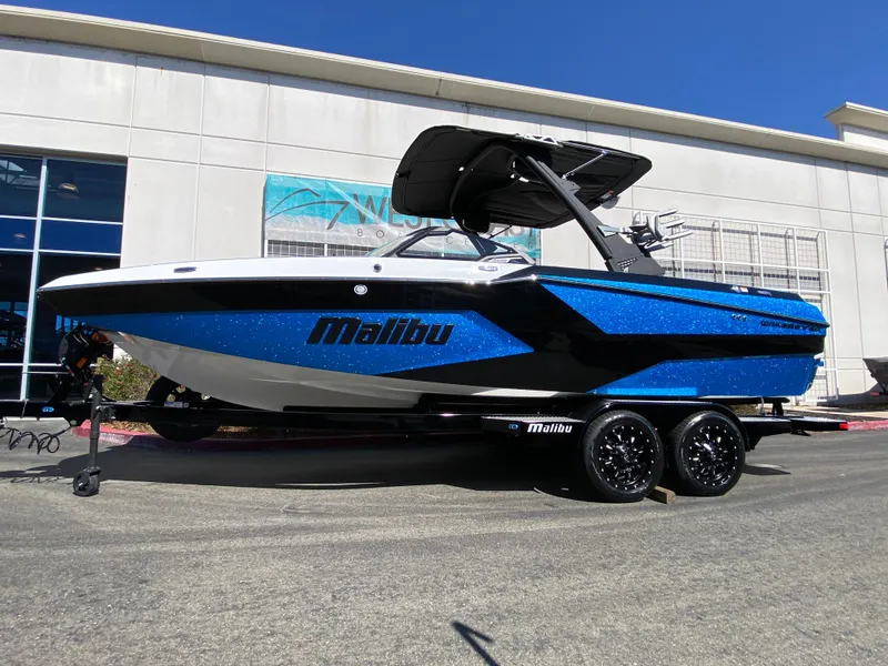 The Image of 2025 Malibu Wakesetter 23 MXZ boat in vibrant blue on a trailer. - 0