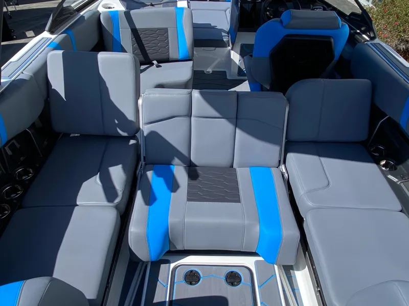 Slide: The Image of 2025 Malibu Wakesetter 23 MXZ interior with gray and blue seating, spacious layout. - 12