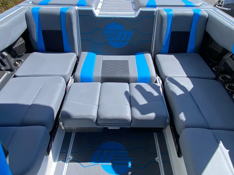 Slide: The Image of 2025 Malibu Wakesetter 23 MXZ interior with blue and gray seating. - 14